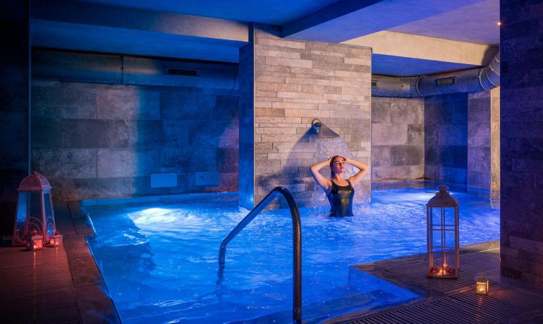 Piscine intérieure avec éclairage doux et ambiance relaxante.