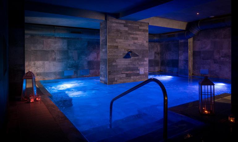 Indoor pool with lanterns and relaxing ambiance.