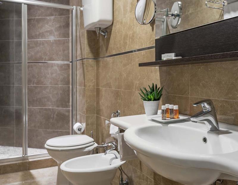 Bagno moderno con doccia, lavandino e accessori eleganti.